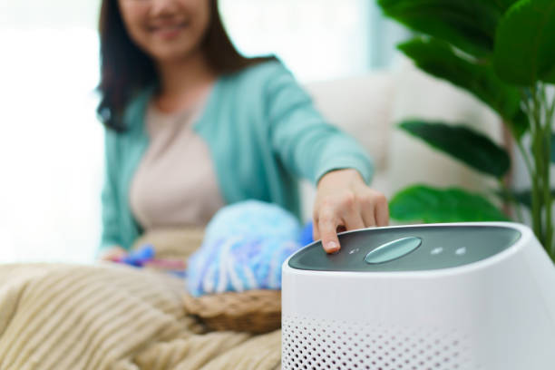 istock Woman using air purifier while stay in living room 1495011512