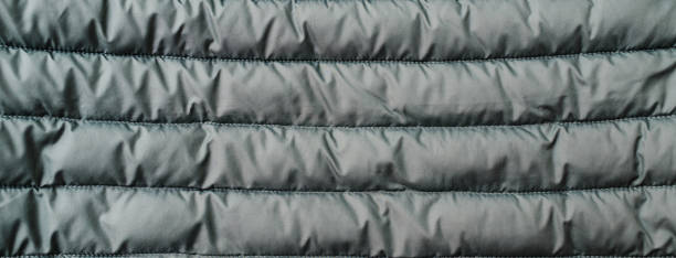 istock Down jacket fabric background, green puffer jacket texture. Top view.Banner. 1495011746