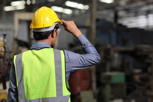 istock Rear view confident technician engineer and worker in protective uniform standing and holding hardhat while controlling operation checking industry machine process at industry manufacturing 1495014360