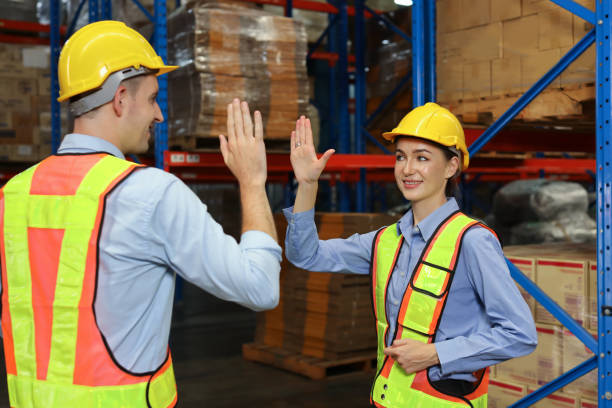 istock Warehouse worker teamwork with hardhat and reflective jacket give high five celebrate successful together completed deal commitment at retail warehouse logistics distribution center, success concept 1495016249
