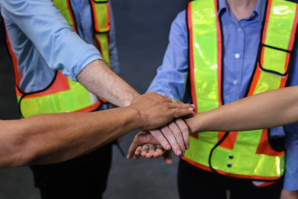 istock Group of engineer or worker in protective suit with hardhat standing and stacking hands celebrate successful together or completed deal commitment at heavy industry manufacturing factory or warehouse 1495016261