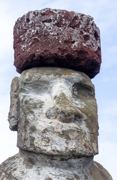 istock Moai Statue Head with Red Hat Close Up Vertical Portrait 1495017241