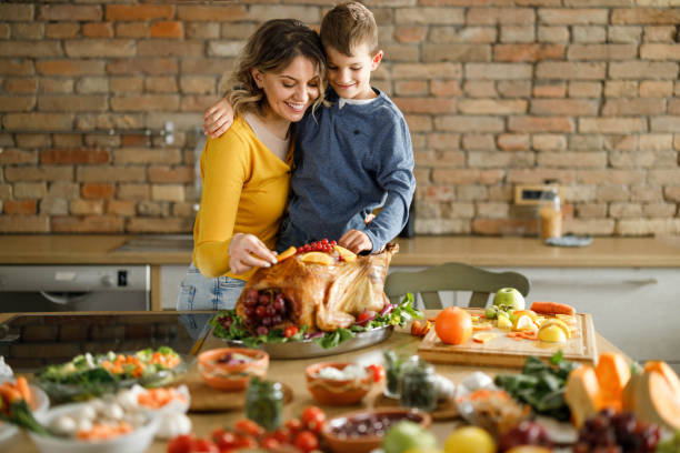 istock Happy single mother and her son decorating Thanksgiving turkey. 1495018336