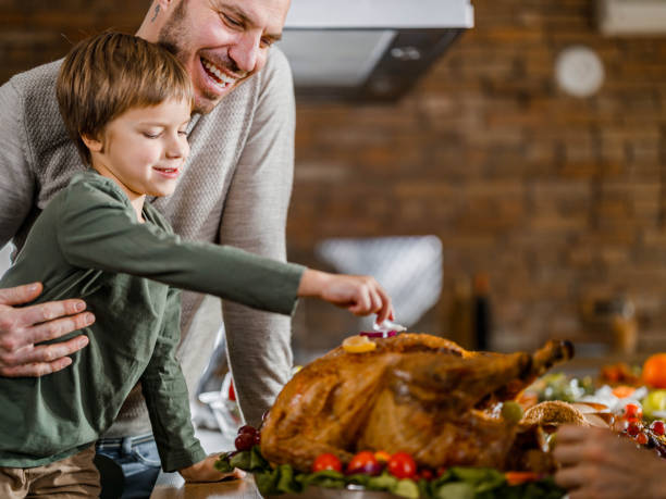 istock Happy single father and son decorating Thanksgiving turkey. 1495018377