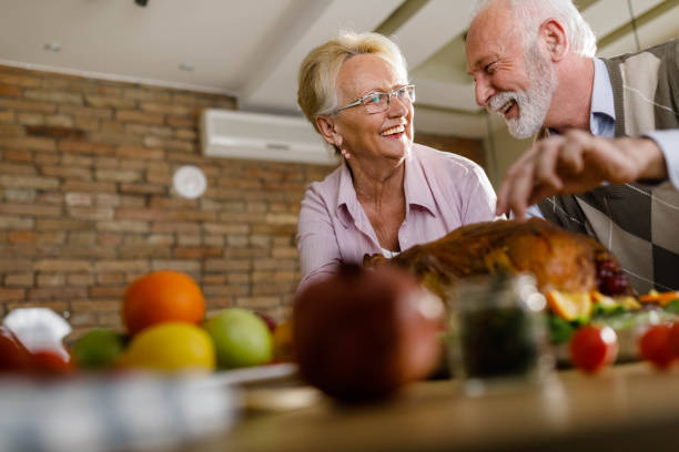 istock Happy mature couple talking while preparing turkey for Thanksgiving day. 1495018962