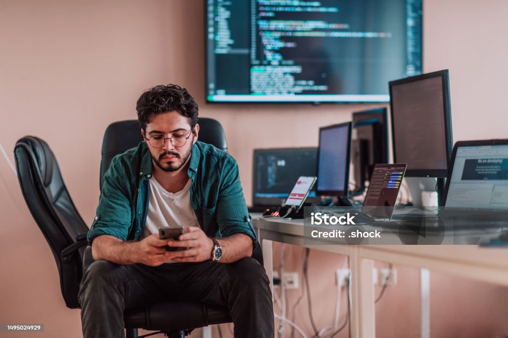 Smartphone Programmer A Programmer Diligently Testing Smartphone Applications While Sitting ...