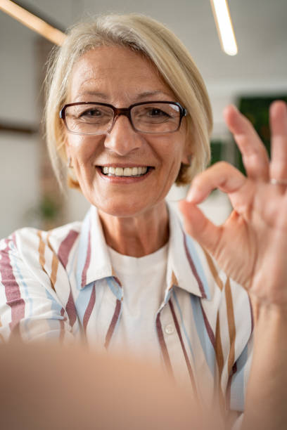 istock Caucasian mature woman taking selfie or having video call using mobile phone 1495025329