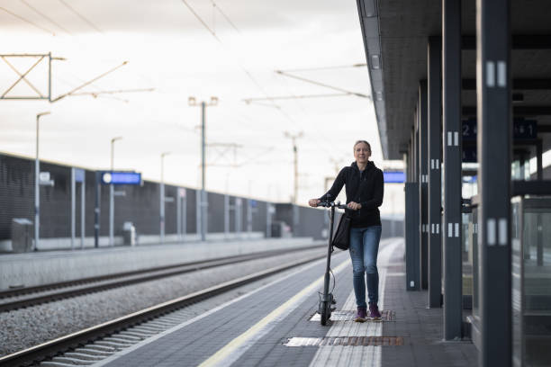 istock woman with e-scooter at railway station platform 1495025886