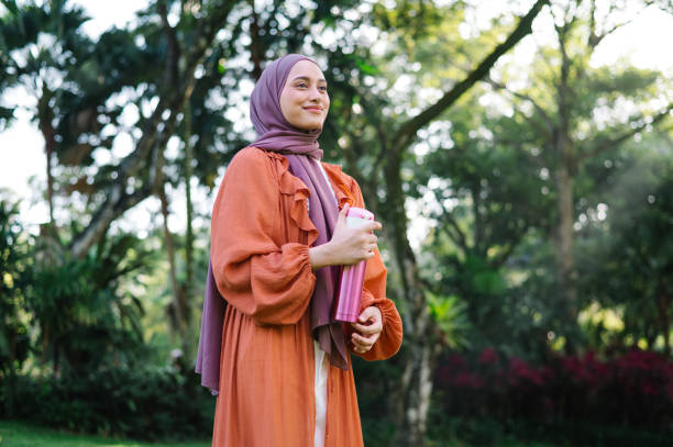 istock Asian Malay female is resting and holding reusable water bottle. 1495025986