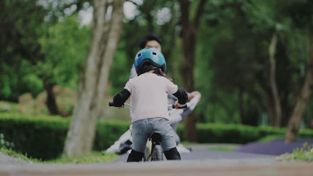 Little girl with helmets practicing balance bike