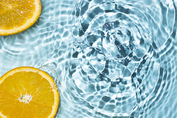 istock Creative summer background with orange fruit slices in swimming pool water. 1495028095