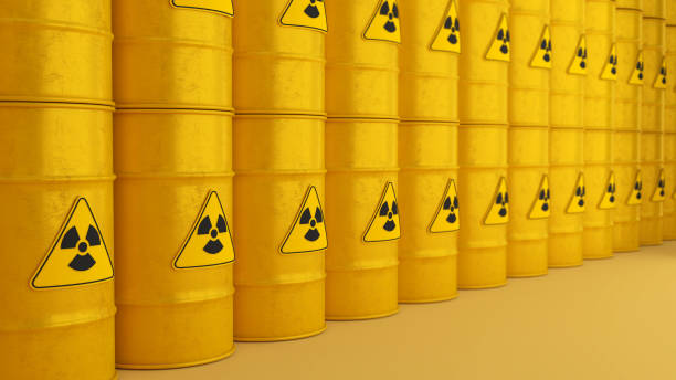 istock Radioactive storage tanks with a warning for chemical and radiation risks on a yellow backdrop.,3d rendering 1495028352