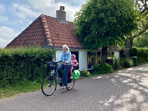 Santpoort , Netherlands - May 31, 2023.  Parent on there daily bike  route to bring het child to school.