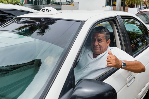 portrait of latin taxi driver senior man with car on background at city street in Mexico in Latin America, Hispanic adult people
