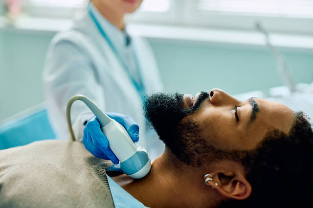 istock Close up of doctor using ultrasound while checking thyroid gland of black male patient. 1495030708