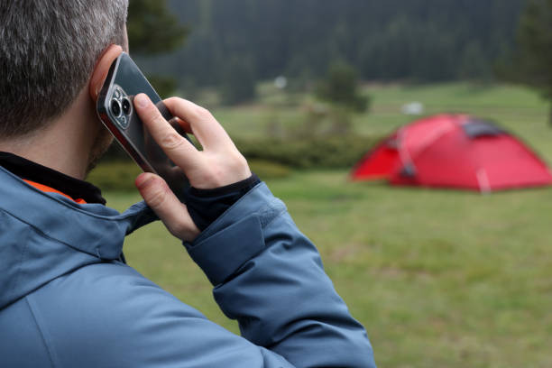 istock Man talking on a smart phone with his tent 1495030813