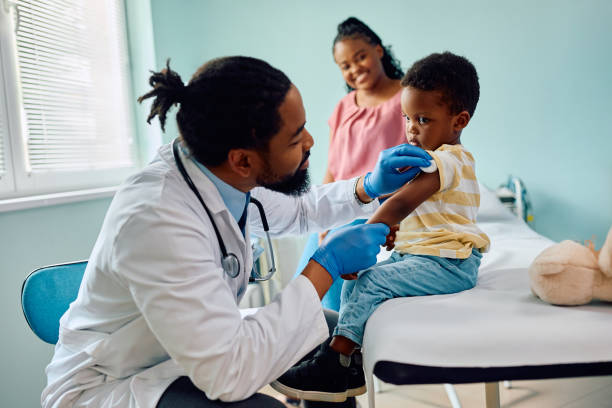 istock Small black boy about to get vaccinated by pediatrician at doctor's office. 1495030817