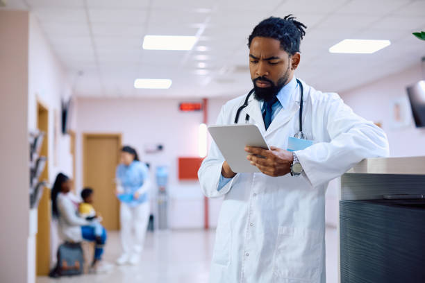 istock Black male doctor using digital tablet at the clinic. 1495030874