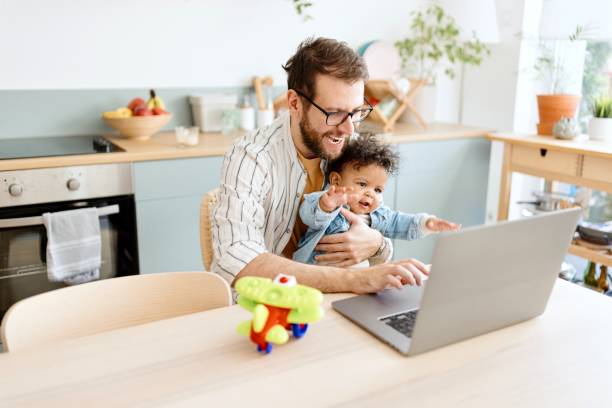 istock Father taking care of his little son while working 1495032396