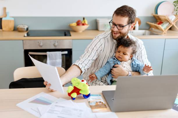 istock Little son playing while his father is working from home 1495032423