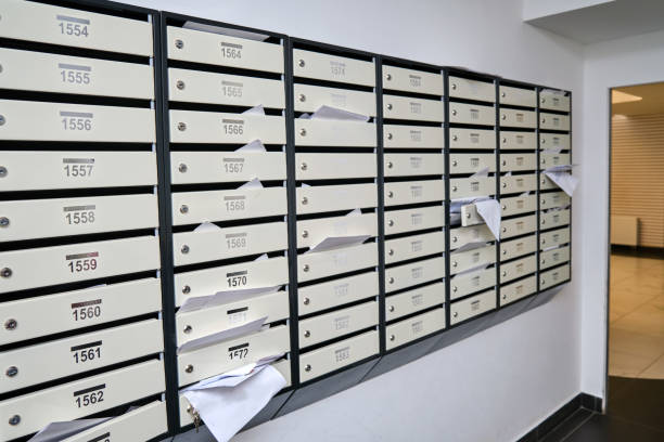 boîtes aux lettres avec des documents et des factures débordants. boîtes aux lettres avec lettres à l’entrée d’un immeuble - stack file paper document photos et images de collection