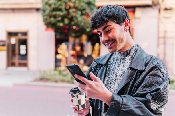 istock Gay man using the mobile and drinking coffee outdoors 1495037342