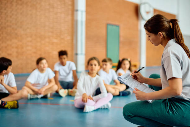 istock Physical education teacher taking notes during a class with school kids. 1495037990