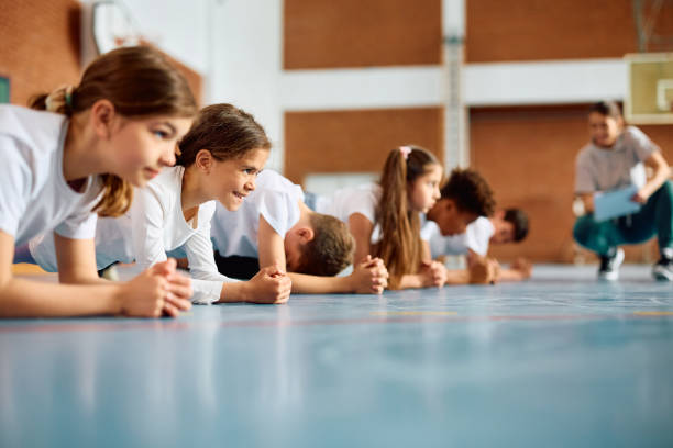 istock Group of elementary students having physical education class at school gym. 1495037993