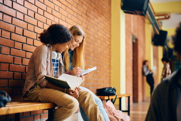 istock Happy female high school students learning together in a hallway. 1495038127