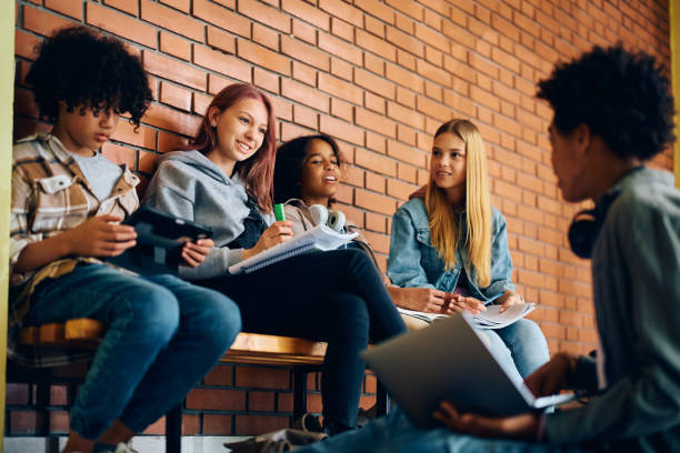 istock Multiracial group of high school friends talking while studying in a hallway. 1495038130