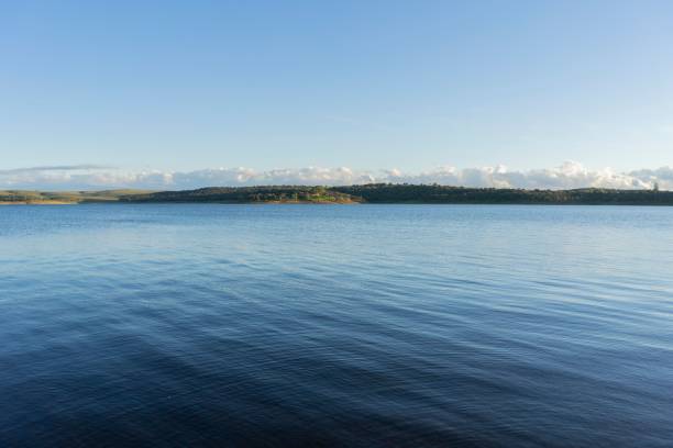 błękitna powierzchnia wody, zbiornik orellana w ciemnoniebieskim zachodzie słońca. plaża nad zbiornikiem orellana. - wavelet zdjęcia i obrazy z banku zdjęć