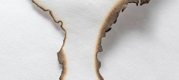 istock burning paper, glowing edge of paper on a white  background 1495041835