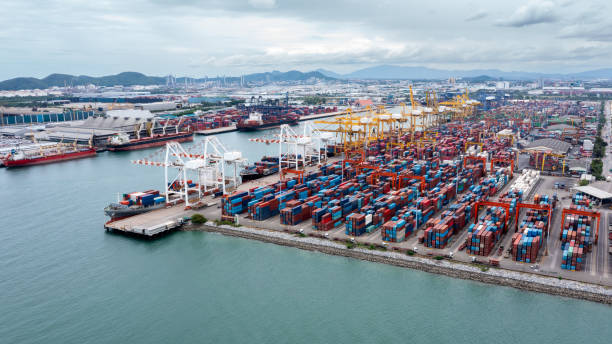 istock commercial port load and unloading cargo from container ship import and export by crane for distributing goods by trailers transported to customers and dealers, aerial view from drone 1495043251
