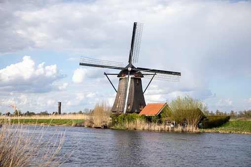 This original old windmill stands in the fields on the popular German holiday island  Foehr in the North Sea.Wheat and Corn Fields surround this beautiful old industrial buildingforeground in focus