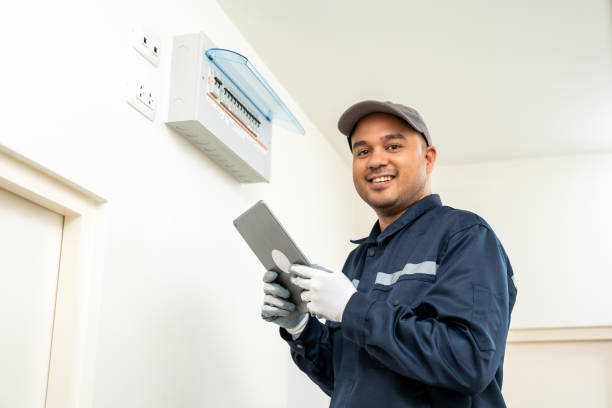 istock Electrician man in uniform using tablet for maintenance or fixing switches sockets  circuit breaker electrical system. Technician fixing an electric fuse at home. Home service concept. 1495043509