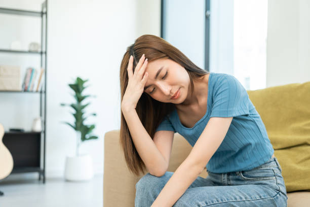 istock Depressed and Stressed asian woman on sofa. Crying sadness female alone in home problem in life. Unhappy asian woman headache Upset frustrated by problem love relationship feeling despair and anxiety 1495043816