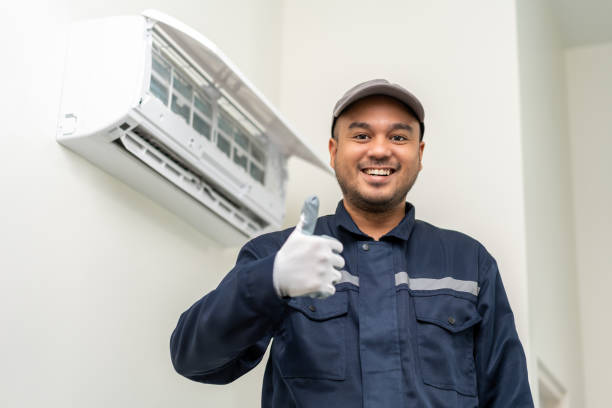 istock Air conditioner service indoors. Air conditioner cleaning technician He opened the front cover and took out the filters and washed it. He in uniform wearing rubber 1495043863