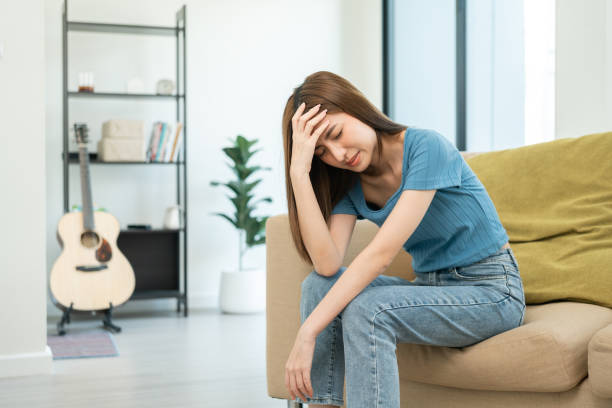 istock Depressed and Stressed asian woman on sofa. Crying sadness female alone in home problem in life. Unhappy asian woman headache Upset frustrated by problem love relationship feeling despair and anxiety 1495045028
