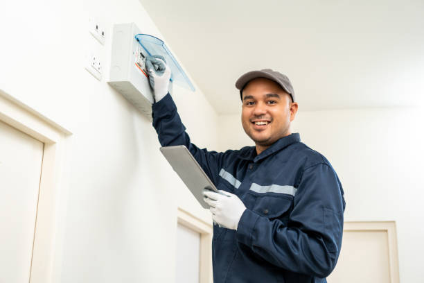 istock Electrician man in uniform using tablet for maintenance or fixing switches sockets  circuit breaker electrical system. Technician fixing an electric fuse at home. Home service concept. 1495045095