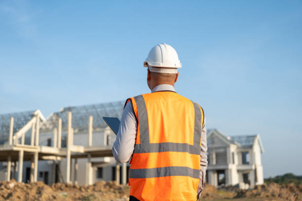 istock Confident asian engineer man Using tablet for checking and maintenance to inspection at modern home building construction. Architect working with white safety helmet in construction site 1495045526