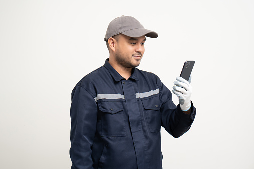 Technician workers in uniform maintenance service with smartphone. Profession of service industry house repair. Home services with cellphone isolated background.