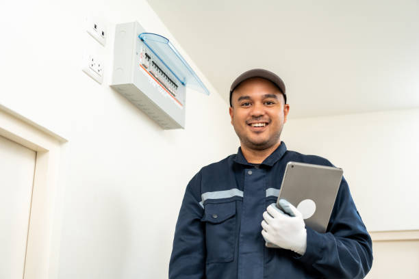 istock Electrician man in uniform using tablet for maintenance or fixing switches sockets  circuit breaker electrical system. Technician fixing an electric fuse at home. Home service concept. 1495045951