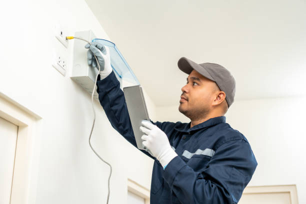 istock Electrician man in uniform using tablet for maintenance or fixing switches sockets  circuit breaker electrical system. Technician fixing an electric fuse at home. Home service concept. 1495046832