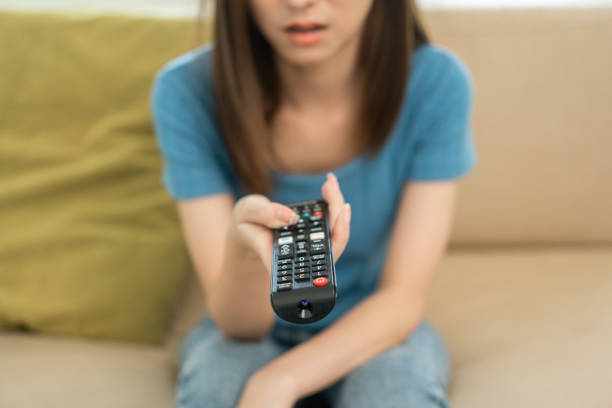 istock Close up woman hand holding remote control pointing to change the programme television menu. 1495047070