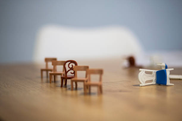 Tiny toy wooden empty chairs in a row close up