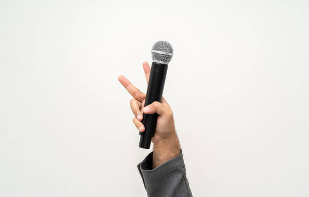 istock Close up businessman speaker hand holding High quality dynamic microphone and singing song or speaking talking with people on isolated white background. Male testing microphone voice for interview 1495048100