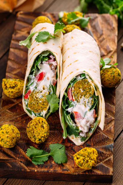 istock Portion of vegetarian falafel wrap roll on board 1495051150