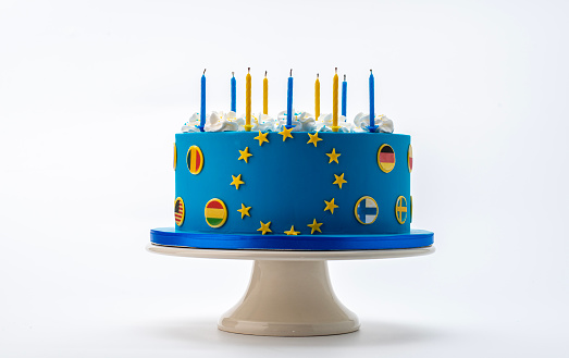 Blue cake with the flag of the European union with yellow stars on a standard.