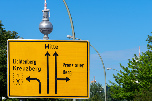 Road direction sign against Berlin communications tower