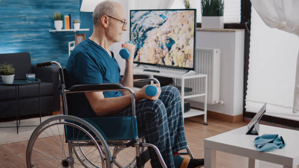 istock Pensioner sitting in wheelchair and doing exercise with dumbbells 1495055139